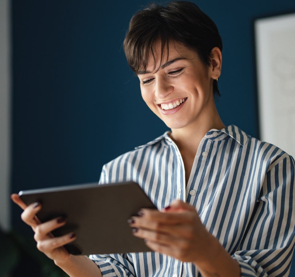Business woman looking at an ipad and smiling